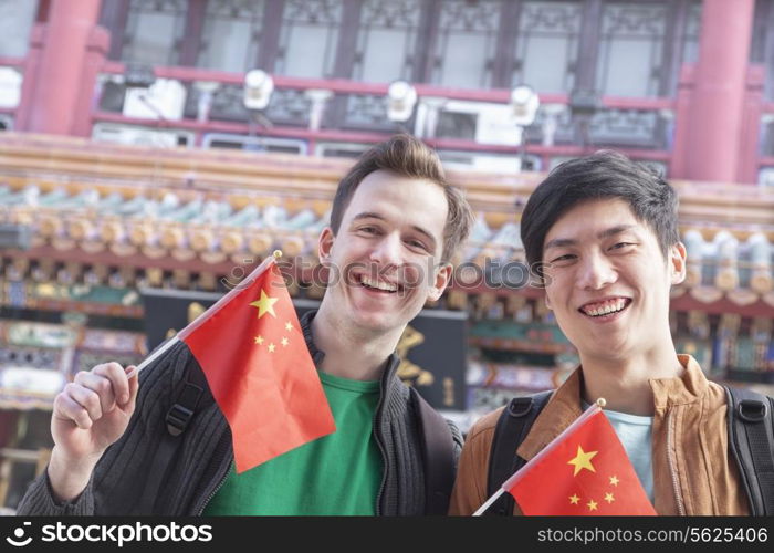 Two young men holding Chinese flags.