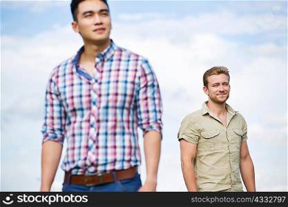 Two young men outdoors, focus on man in background