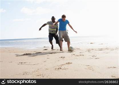 Two Young Men Palying Football On Beach Together