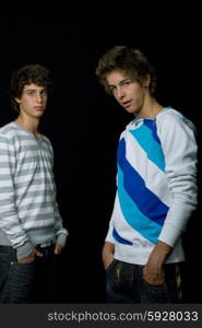 two young men standing, on a black background