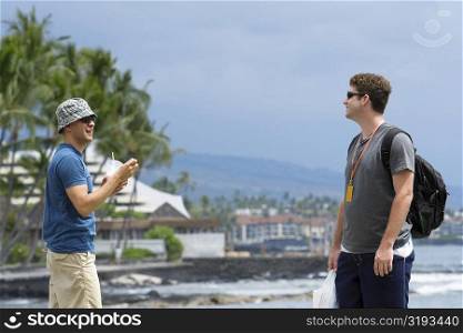 Two young men standing on the beach, Kona, Big Island, Hawaii Islands, USA