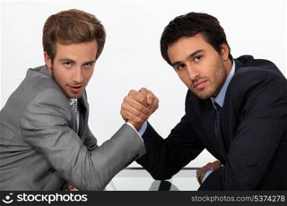 two young men well dressed doing arm-wrest