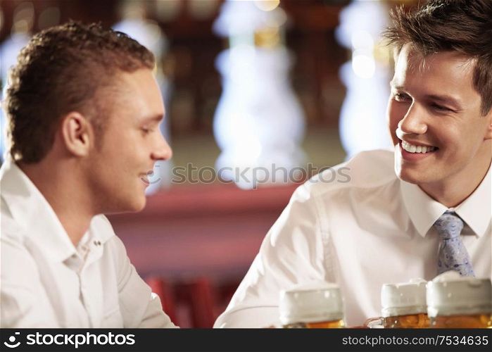 Two young men with a beer in a bar