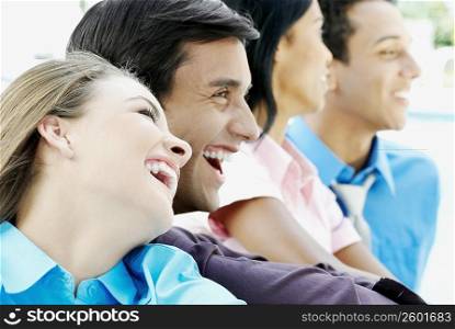 Two young men with a young woman and a teenage girl laughing