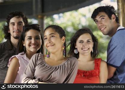 Two young men with three young women posing and smiling