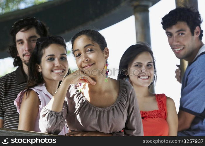 Two young men with three young women posing and smiling