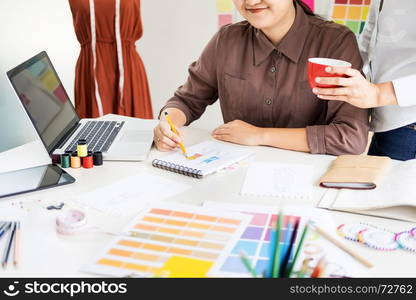 two young men working as fashion designers and drawing sketches and gets fabric advice at a custom tailor