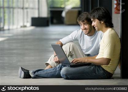 Two young men working on a laptop
