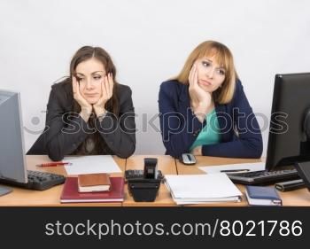 Two young office worker tired of sitting in front of computers