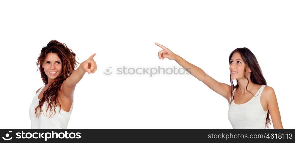 Two young pretty girls indicating something isolated on a white background