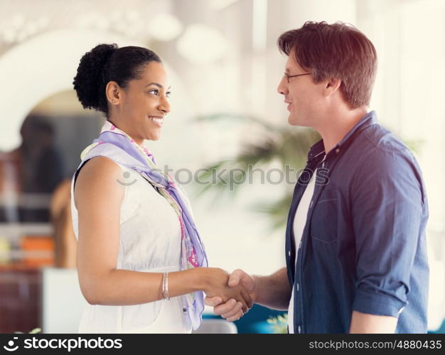 Two young professionals shaking hands