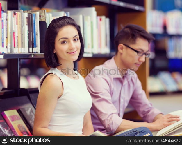 Two young students at the library. Two young students working together at the library