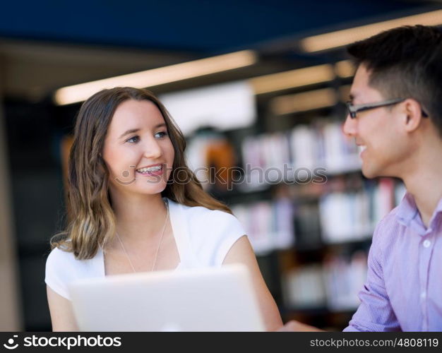 Two young students at the library. Two young students working together at the library