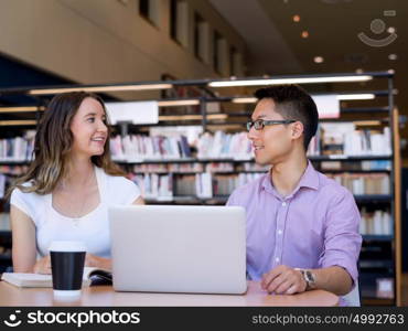 Two young students at the library. Two young students working together at the library