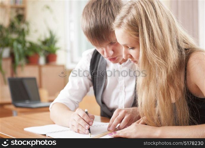Two young teenager studying and helping together