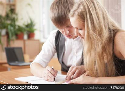 Two young teenager studying and helping together