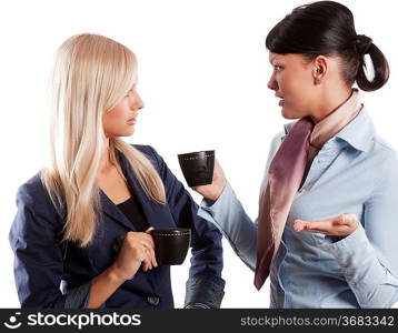 two young woman in formal dress drinking a cup of tea and chatting