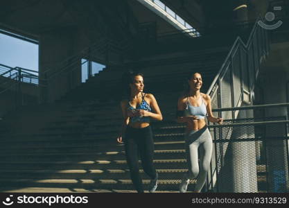 Two young woman jogging in urban enviroment at sunny day