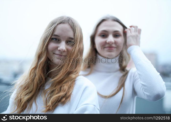 Two young woman looking at camera outdoors. Portrait of teenage girls