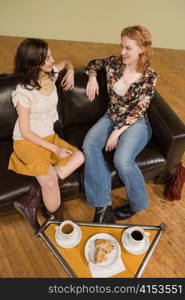 Two Young Woman Sitting over Coffee