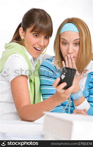 Two young woman with camera looking at pictures
