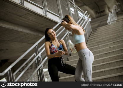 Two young woman workout down stairs in urban environment