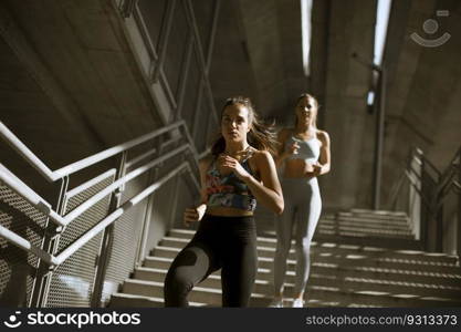 Two young woman workout down stairs in urban environment