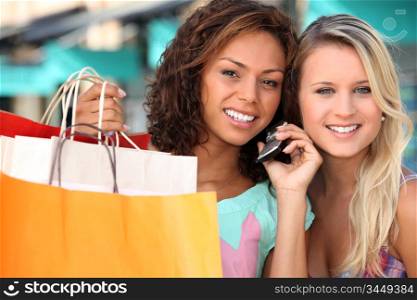 two young women after shopping, one is calling someone