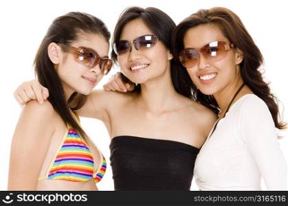 Two young women and a teenage girl wearing sunglasses and smiling