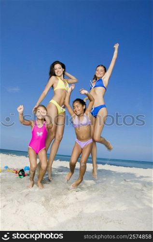 Two young women and two girls playing on the beach
