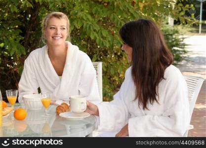 Two young women breakfasting on the patio