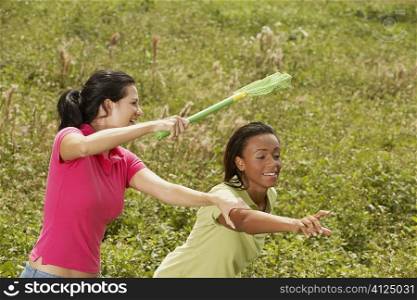 Two young women catching butterflies