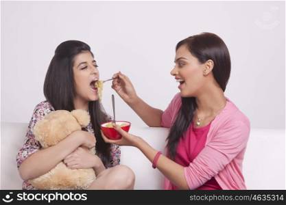 Two young women eating noodles