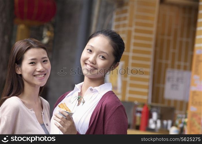 Two Young Women Eating Snacks