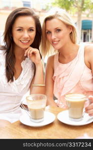 Two Young Women Enjoying Cup Of Coffee In CafZ