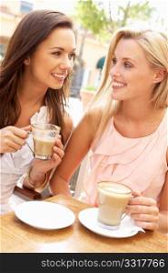 Two Young Women Enjoying Cup Of Coffee In CafZ
