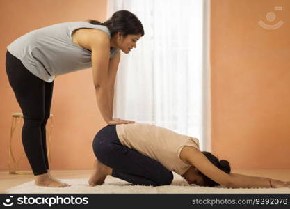 Two young women exercising in living room