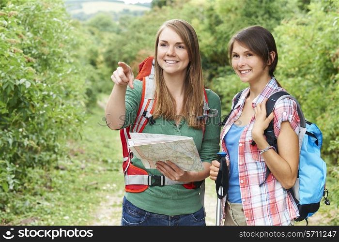 Two Young Women Hiking In Countryside Together