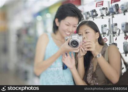 Two young women holding a camera