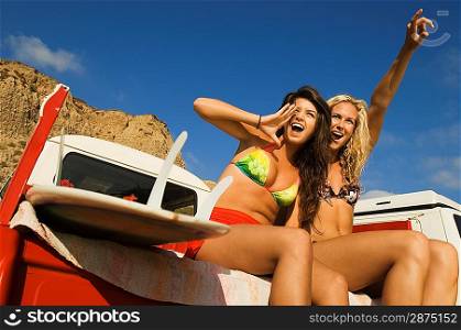 Two Young Women in Bikinis Cheering Surfers