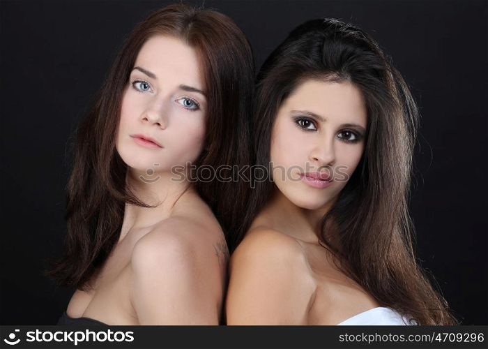 two young women - isolated on dark