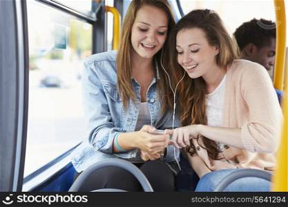 Two Young Women Listening To Music On Bus