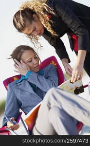 Two young women looking at a magazine and talking