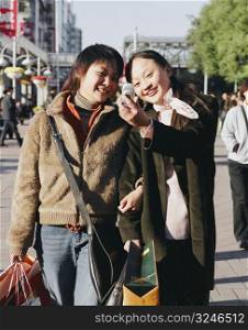 Two young women looking at a mobile phone and smiling