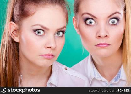 Two young women looking shocked surprised stunned. Human emotion face expression. Two young women looking shocked