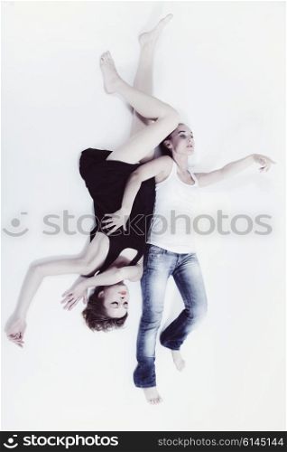 Two young women lying on white floor