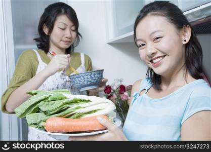Two young women preparing food in a kitchen