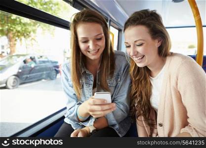 Two Young Women Reading Text Message On Bus