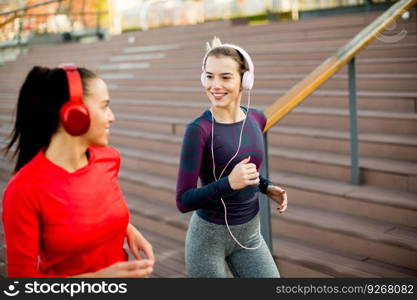 Two young women running in urban area