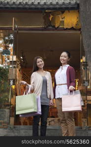 Two young women shopping looking at the Camera